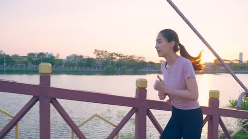 Asian young beautiful sport woman running on street in public park.