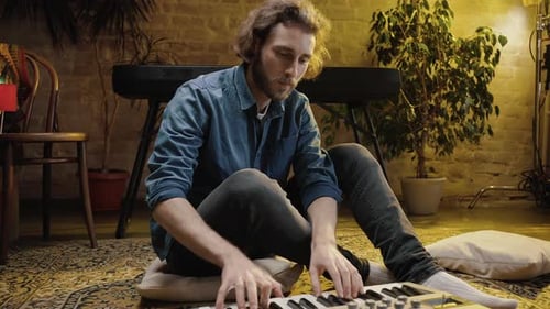 Man Plays Electric Piano at Home on Floor
