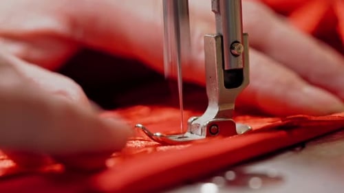 Process of sewing machine working with red fabric.