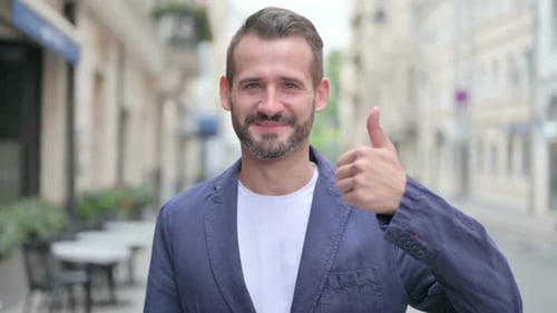 Man Giving Thumbs Up on City Street