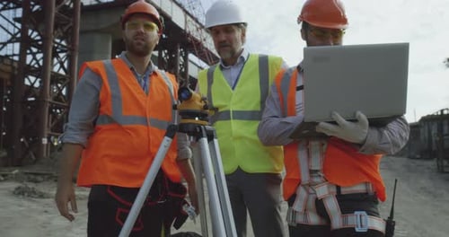 Male Engineers Discussing Plan on Construction Site