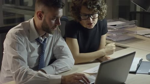 Workaholics Discussing Document at Night
