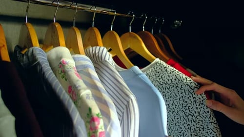 Selecting Shirts from a Colorful Clothing Rack