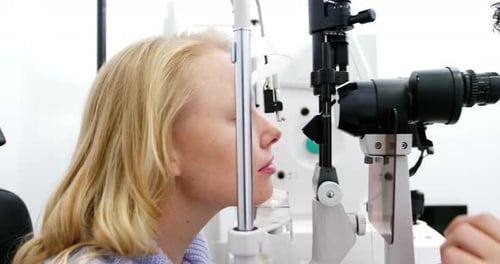 Augenoptiker untersucht Patientin an Spaltlampe