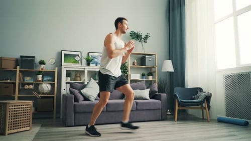 Man Performing Forward Lunges in Bright Living Room