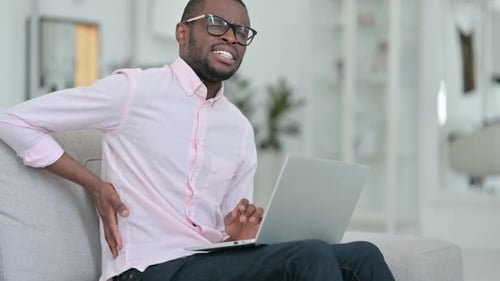 Man Working on Laptop Experiences Back Pain