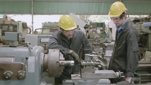 Ingenieurausbildung mit Vorarbeiter für Lehrling mit Drehmaschine, Lehrlingsunterricht mit Arbeiter.