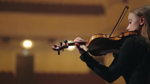 Young Woman Plays Violin in Concert Hall