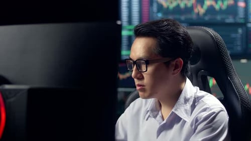 Stock Market Broker Working On Computer With Analyzing Graphs On Multiple Computer Screens