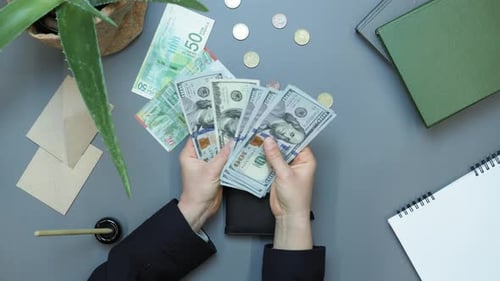 Hands pull cash money out of black wallet