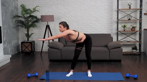 Woman Exercising and Stretching at Home on Yoga Mat