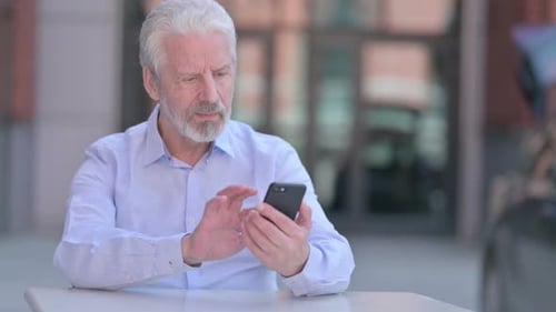 Man Using Smartphone Outdoors in City Setting
