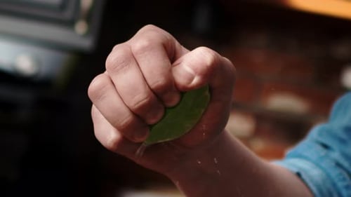 Handheld video of hand squeezing lime.