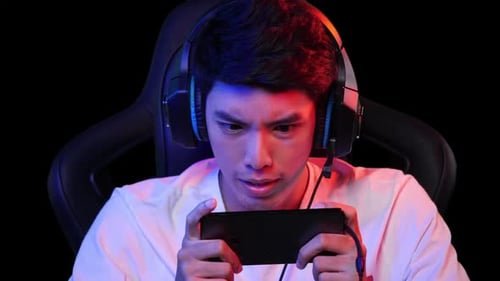 Young Adult Gamer Playing Mobile Game on Phone