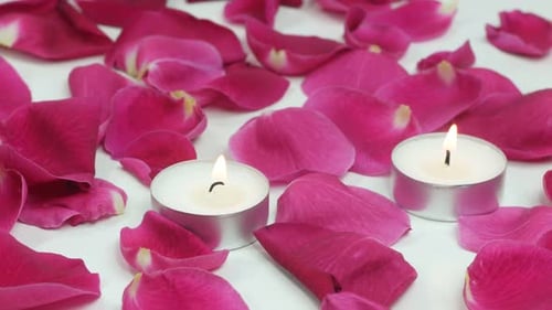Romantische Rosenblätter und Kerzen