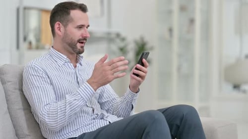 Man Celebrates Good News on Smartphone