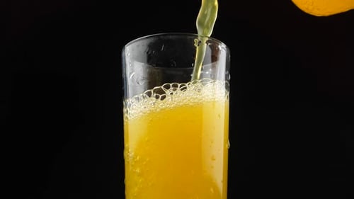 Glass Filled with Sparkling Yellow Beverage