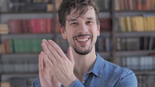 Klatschender lässiger junger Mann applaudiert für Team