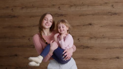 Woman Dancing with a Cheerful Girl Indoors