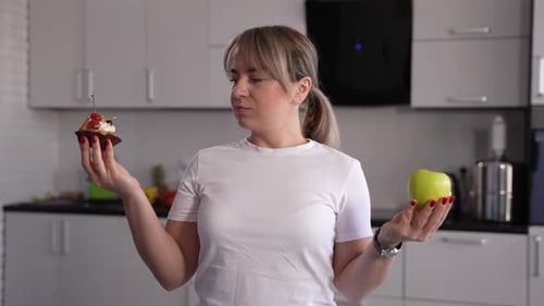 Woman Deciding Between Apple and Cupcake