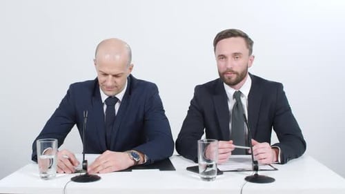 Two Men Presenting News Behind a Desk