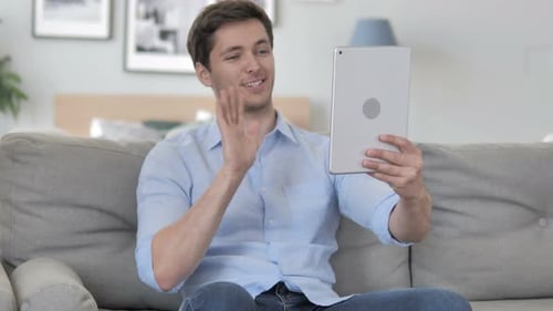 Young Man Video Calling on Tablet at Home