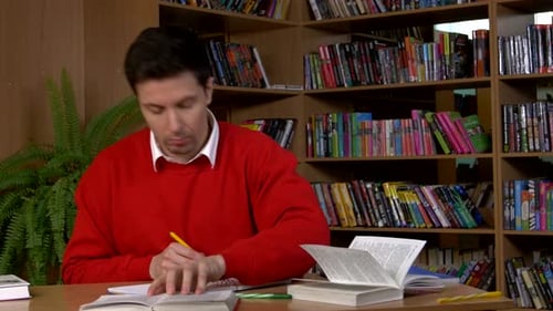 Young Man at the Library. He Is Looking at the Camera - Smiling