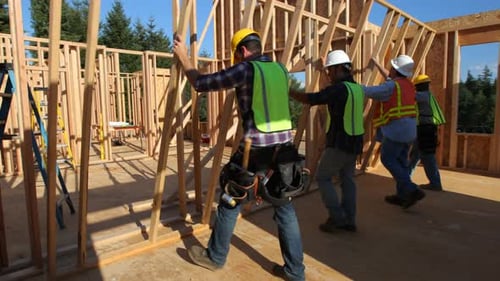 Group of construction workers standing up wall