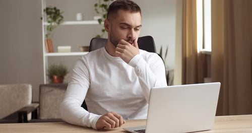 Man Working on Laptop in Bright Home Office