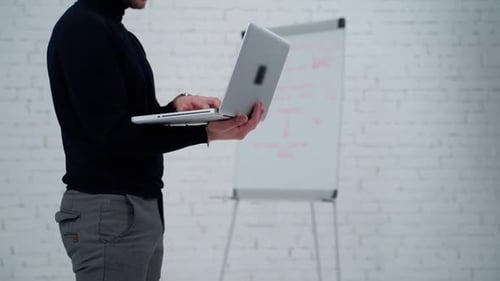 Businessman working with laptop. Close up view of standing man working on laptop
