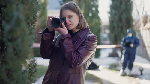 Woman Photographs Crime Scene with Crime Scene Investigator