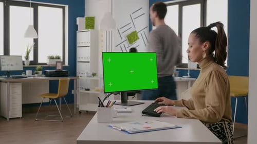 Woman Using Computer with Isolated Green Screen at Desk