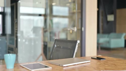 Young Adult Opens Laptop at Modern Office Desk
