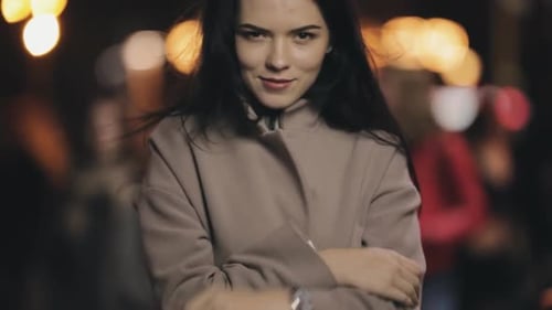 Coquete de mulher atraente posando para a câmera na cidade noturna, câmera lenta