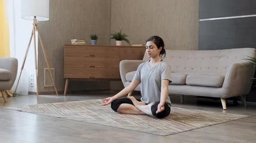 Young Woman Doing Yoga in a Living Room