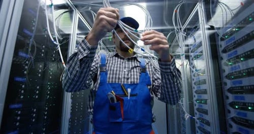 Technician Checking Cables at a Data Center