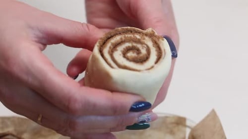 Eine Frau legt geschnittenen Teig mit Zimt in eine Auflaufform zum Backen von Zimtbonbons. Nahaufnahme
