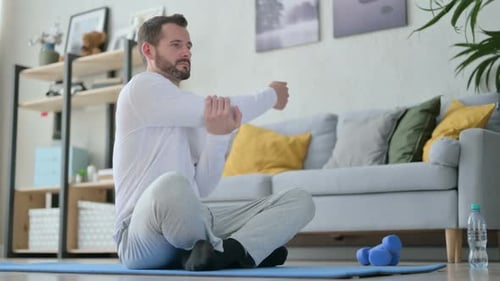 Man Stretching at Home on Yoga Mat