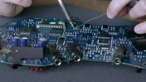 Soldering Iron Repairing a Blue Computer Circuit Board