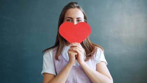 Woman Smiling Holding Red Heart Shape