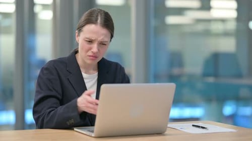 Woman Expresses Frustration While Working on Laptop