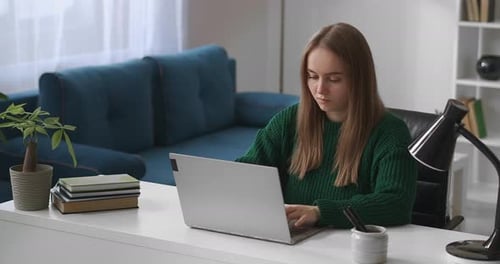 Young Woman Working on Laptop at Home Office