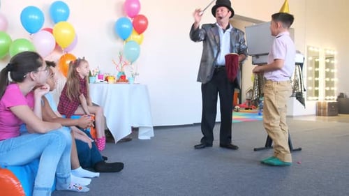 Performer in Silver Jacket Shows Magic Tricks at Party