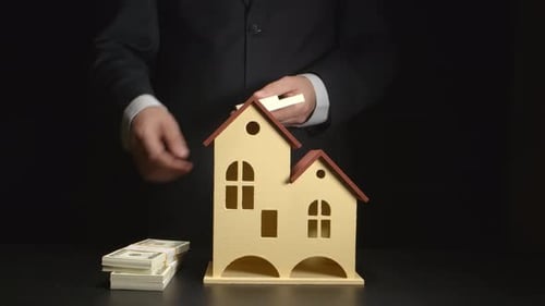 Placing Money on a Wooden House