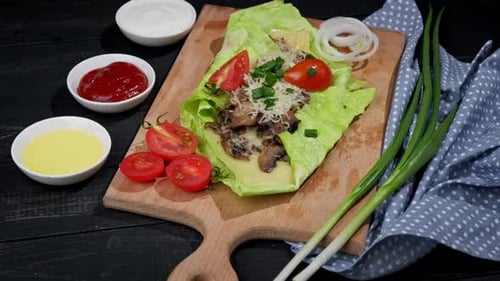 Vegetarian Green Pita Bread with Mushrooms and Cheese Rotates on a Wooden Table