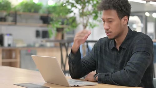 Stressed Young Adult Working on Laptop