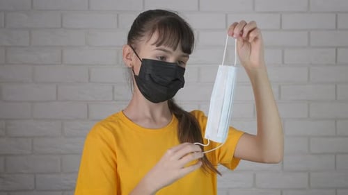 Girl in Face Mask Presents Surgical Mask