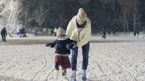 Little Girl Practicing Ice Skating with Mother