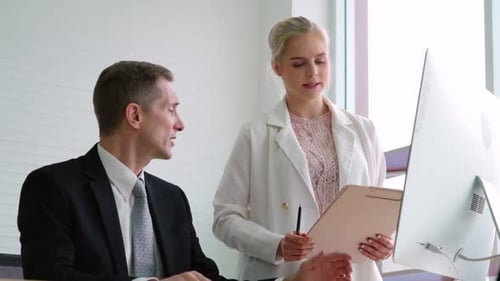 Two Business People Talk Project Strategy at Office