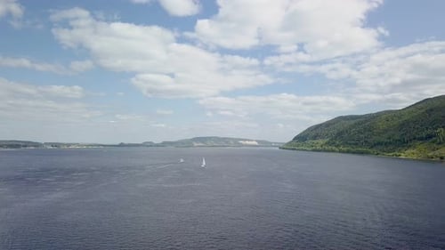 Aerial Shot with Wide River, Sailboat and Picturesque Clouds in Sunny Summer Day